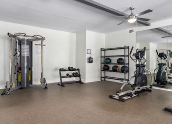 Fitness center with ceiling fans and various exercise equipment.